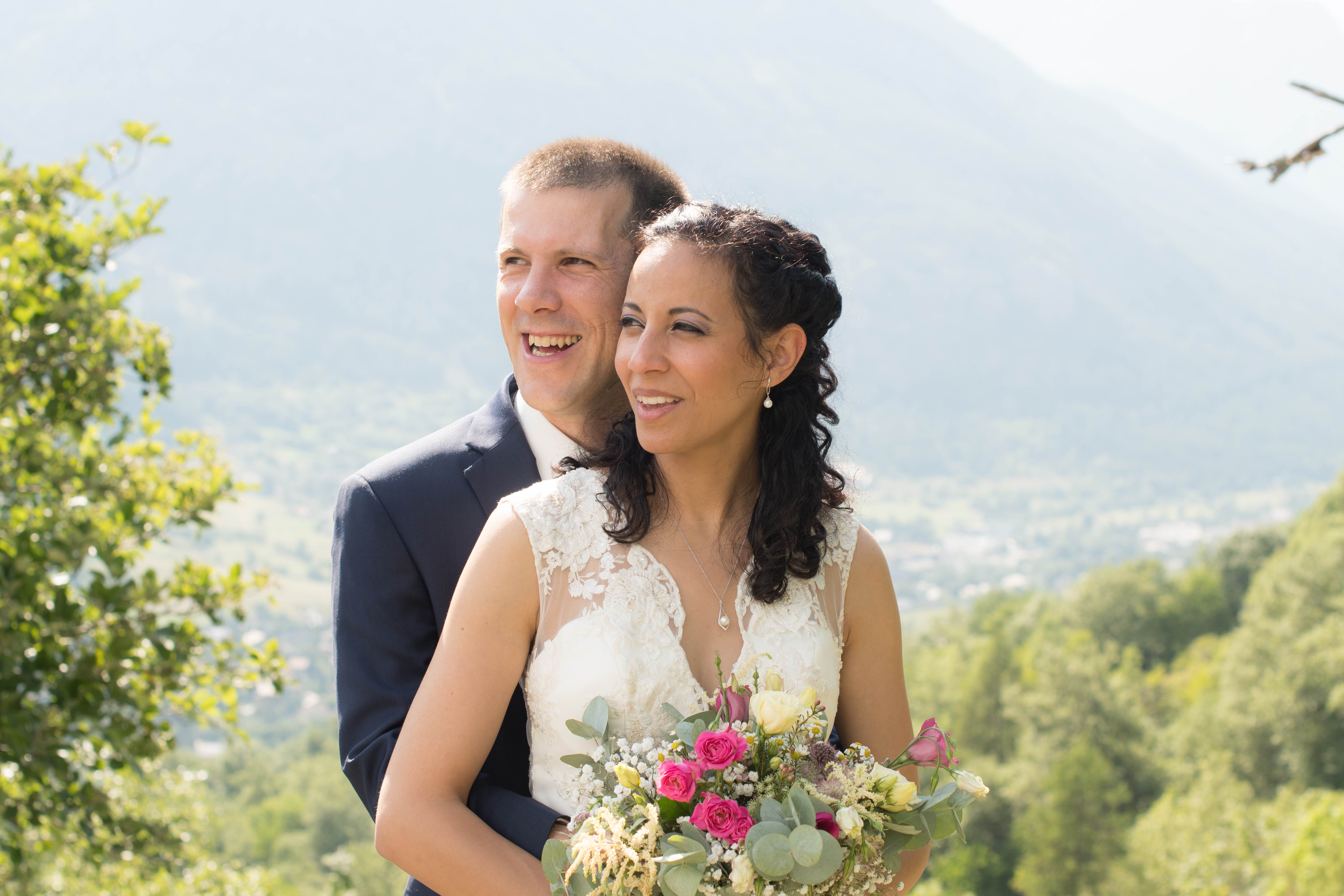 Mariés souriants devant la vallée verdoyante des Hautes-Alpes
